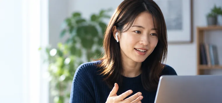 Learner practising English speaking on a laptop with earphones